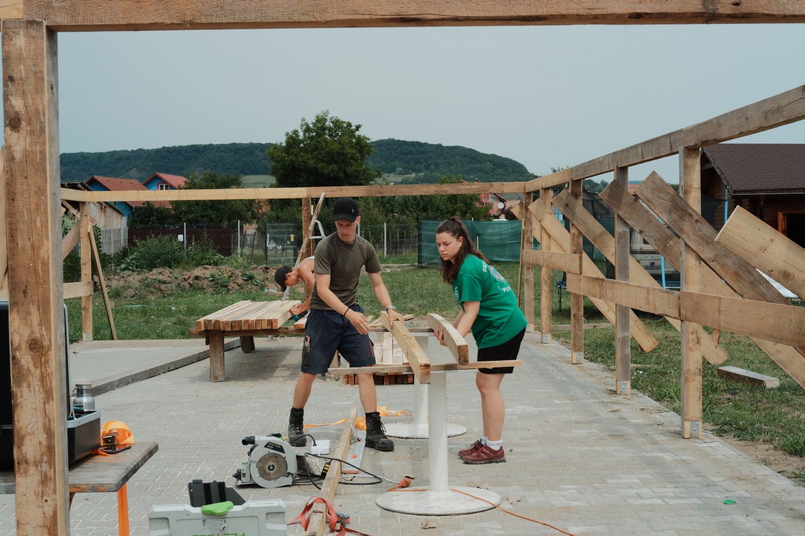 Volunteers cutting timber on the concrete slab of the new building